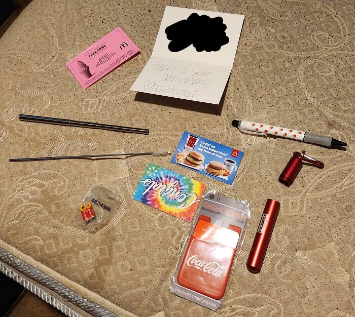 Various small items and vouchers displayed as company gifts and bonuses on a mattress.