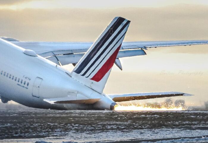Jetliner tail scraping runway, sparks flying; an unfortunate incident likely to be costly.