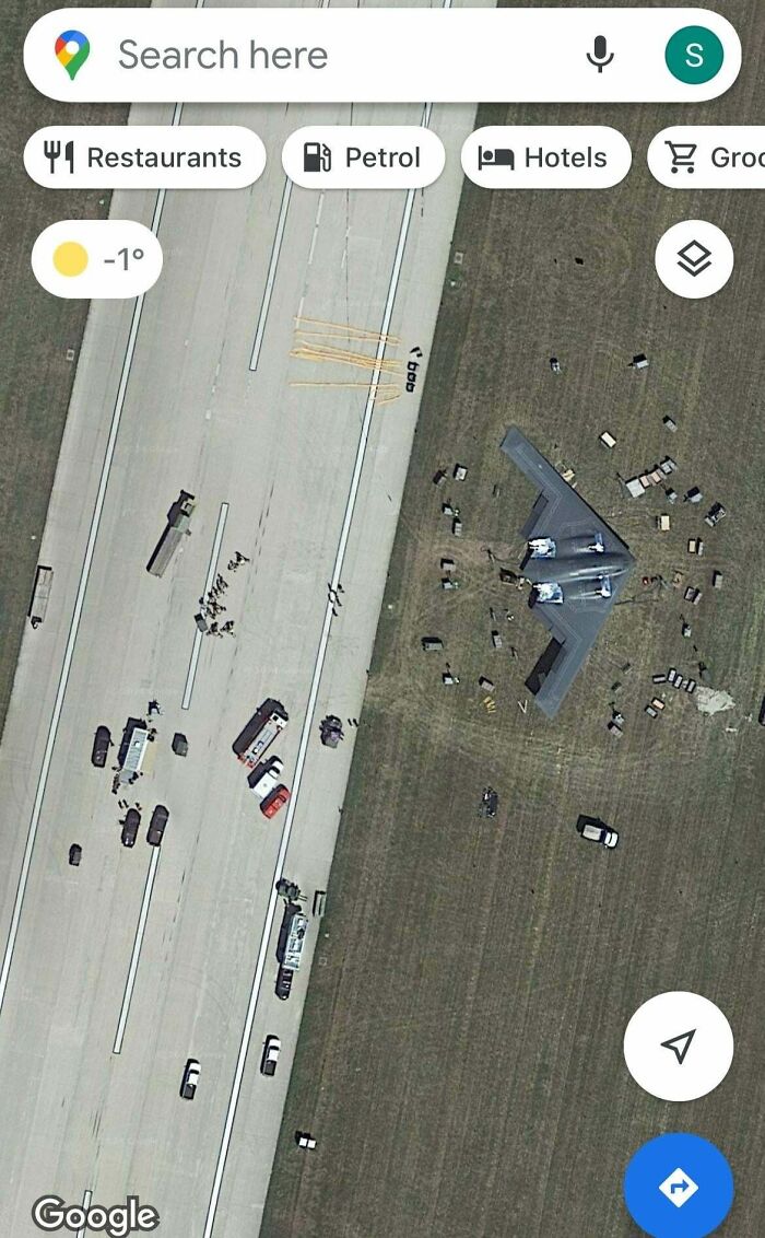 Aerial view of an airfield incident, possibly costly, with emergency vehicles around a large aircraft.