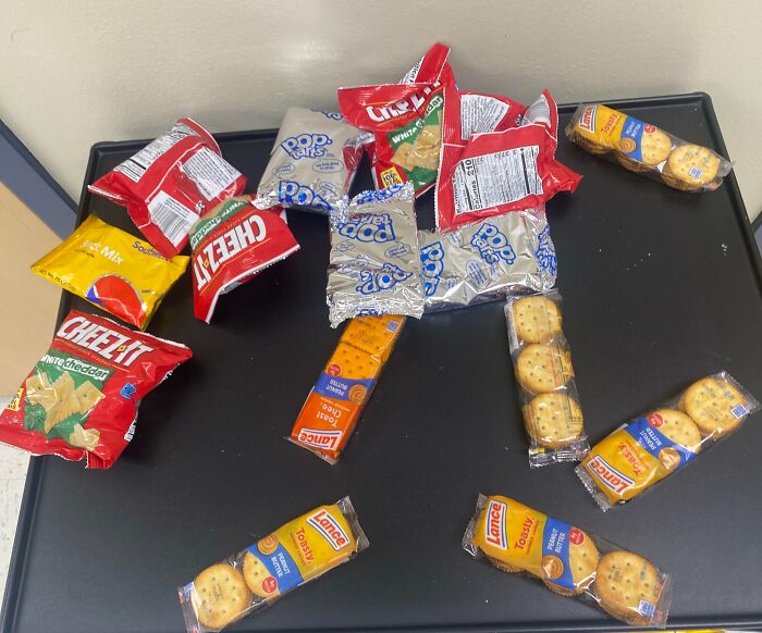 Assorted snack packs as infuriating company gifts on a dark surface.