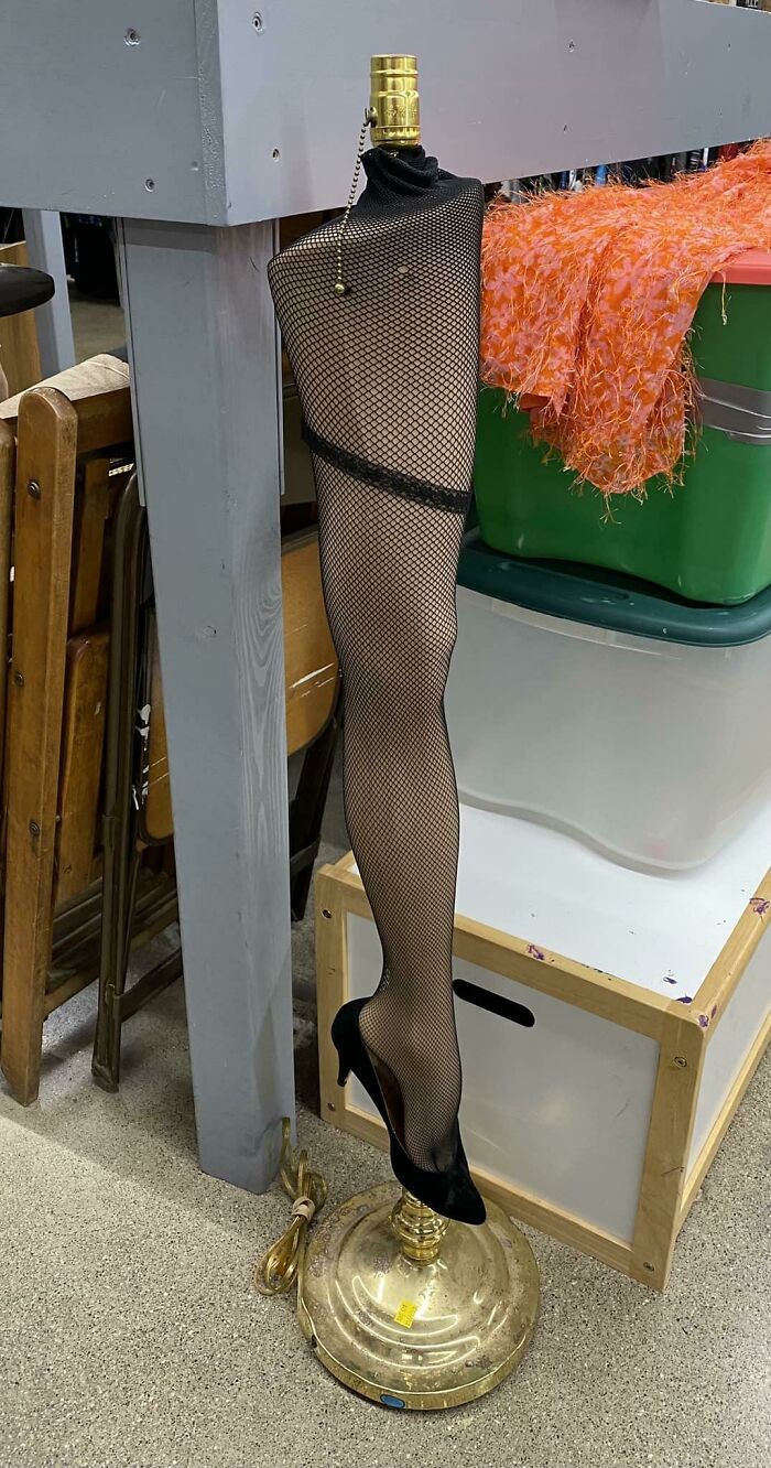 Secondhand find: a lamp designed like a leg in fishnet stockings and high heels, featuring a gold base.