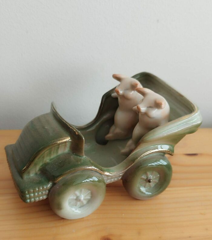 Porcelain pig figurines in a car-shaped dish; a quirky secondhand find.