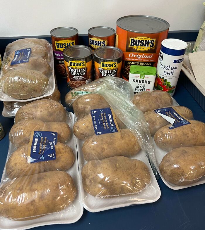 Company gifts of potatoes, canned beans, and spices displayed on a table.
