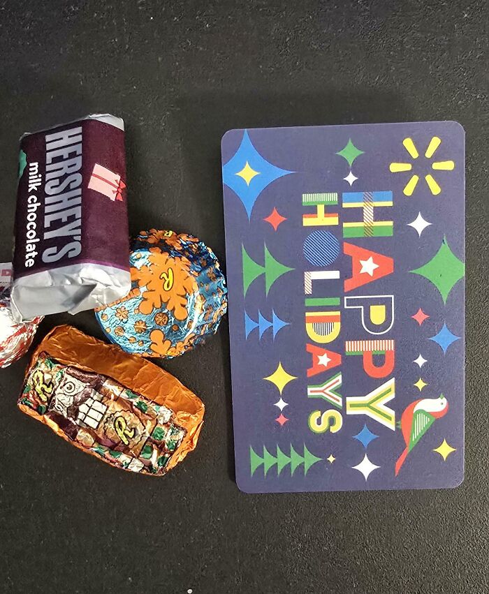 Company gifts including chocolates and a "Happy Holidays" card on a dark surface.
