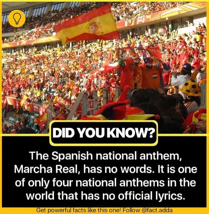 Crowd with Spanish flags in a stadium, highlighting a fascinating fact about the wordless Spanish national anthem.