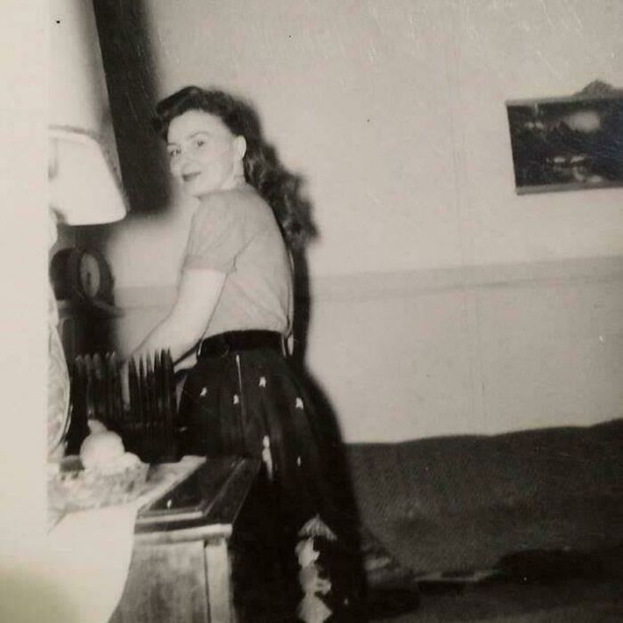 Vintage black and white photo of a woman smiling indoors, one of the fascinating old images not seen in history class.
