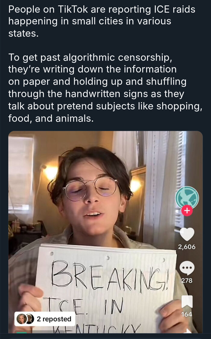 Person holding a handwritten sign on TikTok to bypass censorship, highlighting modern life and boring dystopia themes.