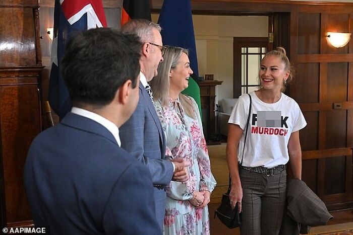 People in a room talking, one wearing a bold shirt, illustrating the Australian community vibe.
