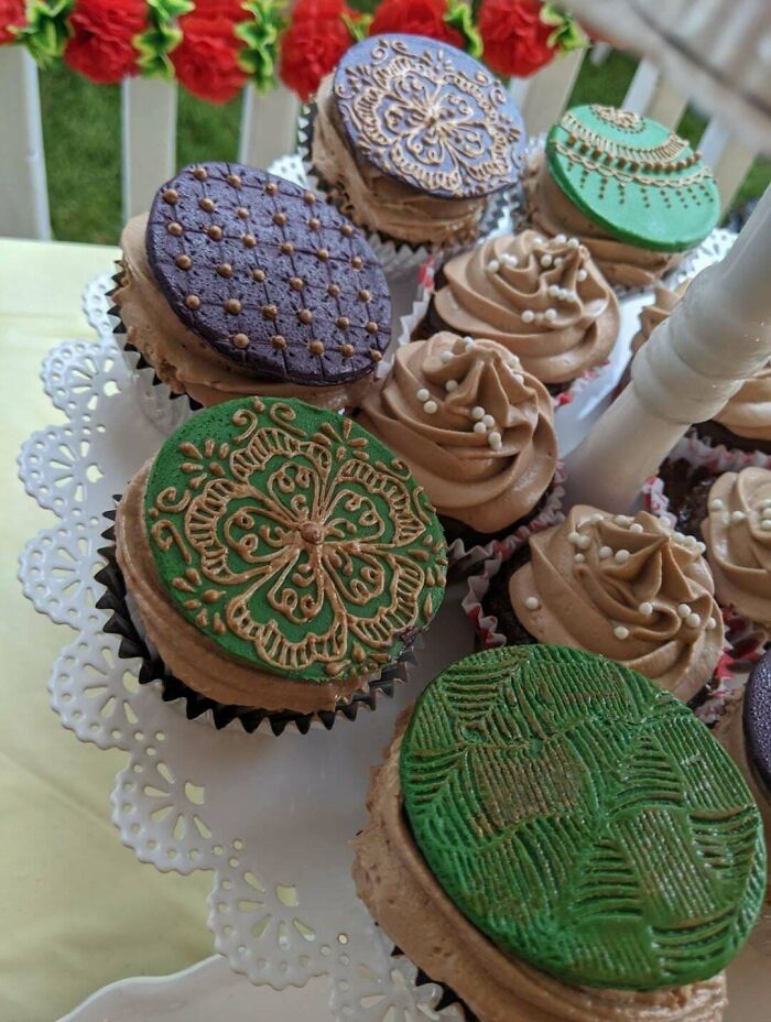 Decorated cupcakes on a tray showcasing intricate icing designs, highlighting creative culinary concoctions.