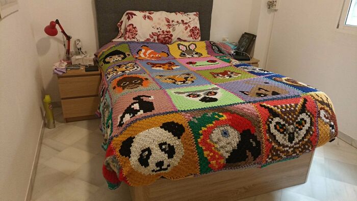 Colorful crochet blanket with animal faces displayed on a bed, showcasing intricate crochet masterpieces and vibrant patterns.