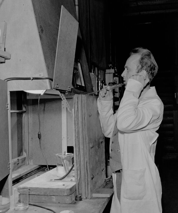 Person in lab coat adjusting neck device in historical scientific experiment, exemplifying overlooked historical events.