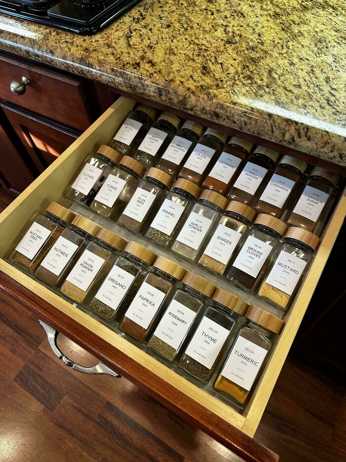 Neat spice drawer organization with labeled jars, showcasing next-level tidiness.