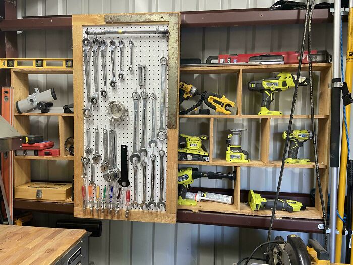 Neat organization of tools on a pegboard and shelves in a workshop, showcasing next-level organization skills.