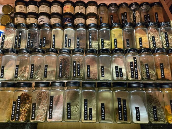 Neat organization of spice jars in a drawer, showcasing labels and next-level arrangement.