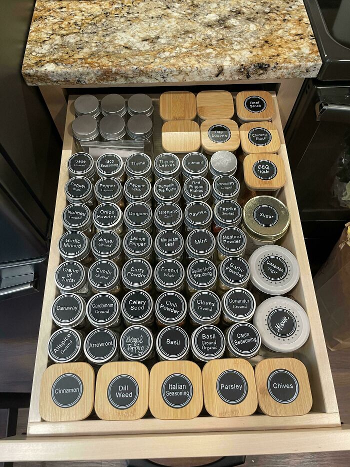 Neatly organized drawer of labeled spice jars showcasing next-level organization.