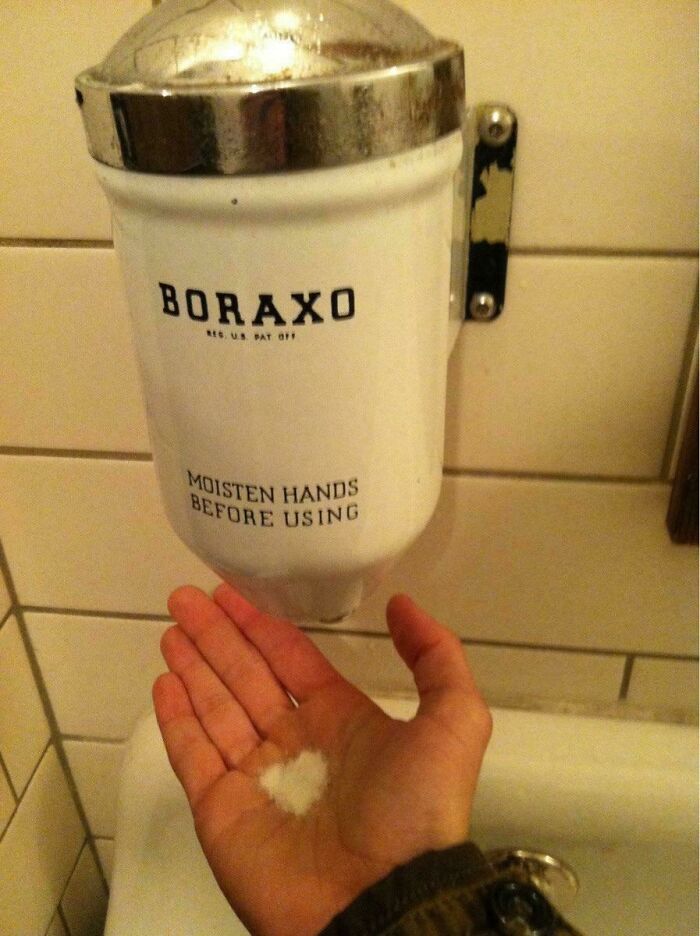 Hand under vintage Boraxo dispenser, symbolizing old-school memories.