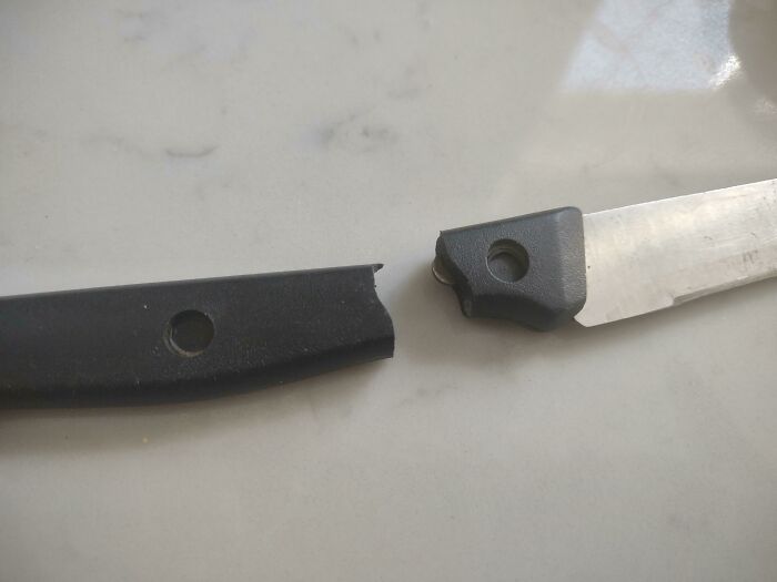 Broken knife handle on marble surface, illustrating low-quality items.