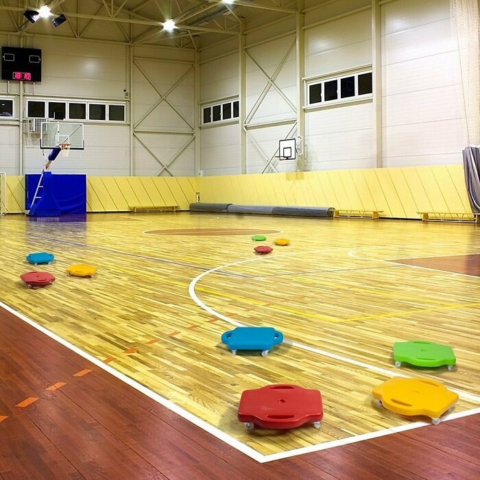 Colorful gym floor scooters evoke old-school memories in a wooden basketball court setting.