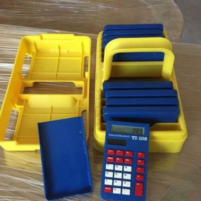 Old-school calculator set in a yellow plastic holder, evoking memories of classroom learning.