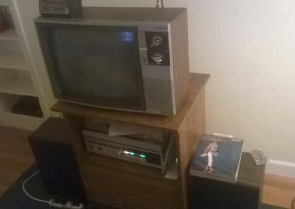 Retro TV set with a VHS player on a wooden stand, evoking sentimental memories of the good old days.