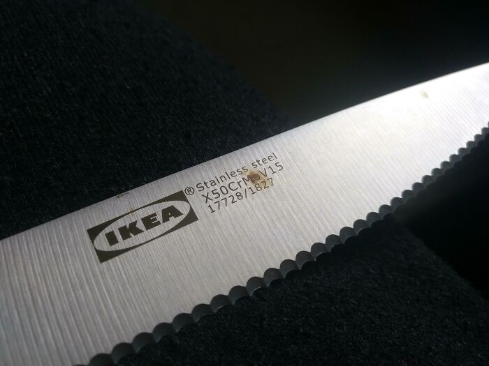 IKEA knife blade close-up showing low-quality item with serrated edge and product details engraved.