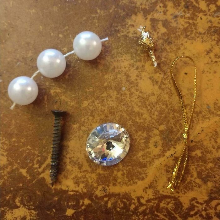 Various shiny objects like pearls, a s***w, and a gem collected by crows.