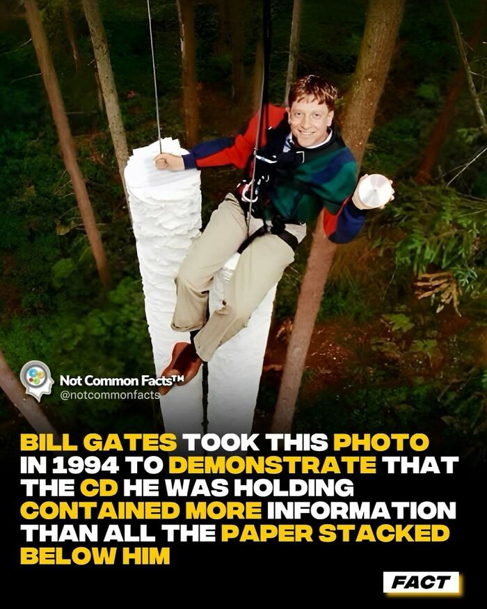 A man hanging with paper stacks in a forest, illustrating a fact about CD data capacity.