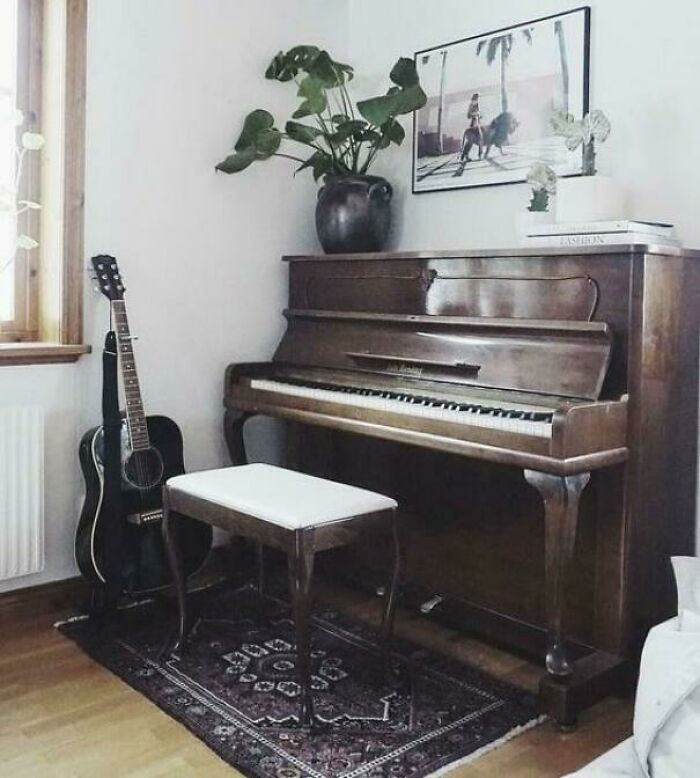 Vintage upright piano and acoustic guitar in a cozy room, evoking nostalgic photos and classic musical memories.