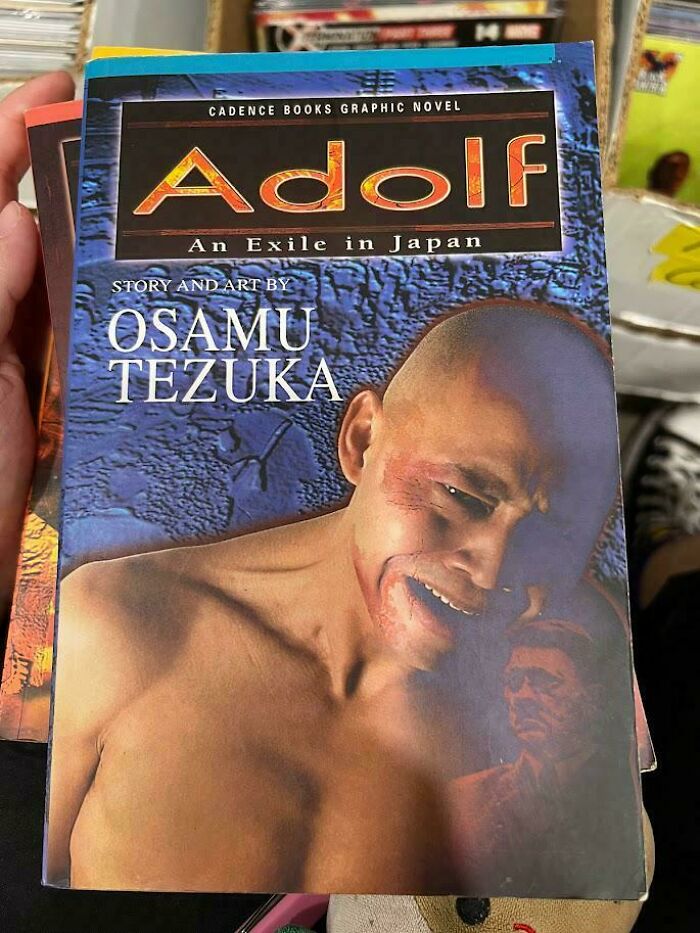 Terrible book cover featuring "Adolf" graphic novel by Osamu Tezuka, showcasing a dramatic and emotional scene.
