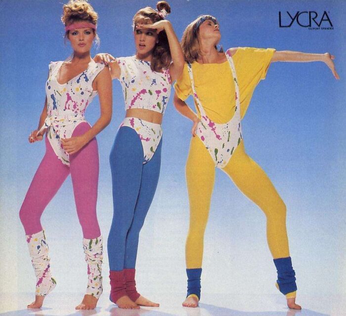 Women showcasing vibrant 80s fashion trends in colorful leggings and tops with abstract patterns.