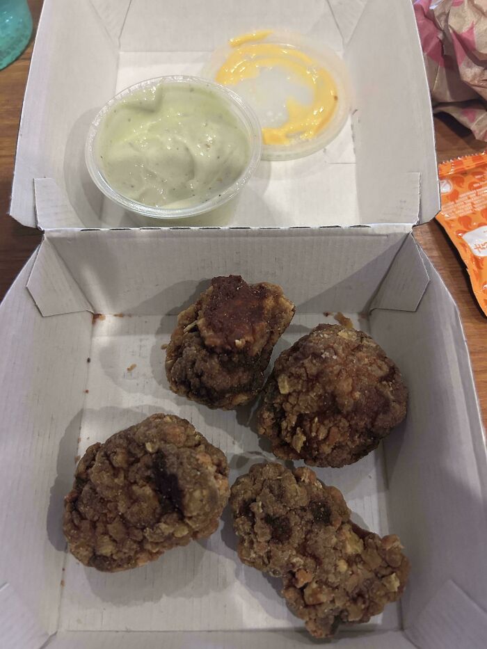 Box of four small fried food pieces with two dipping sauces, illustrating food scams.