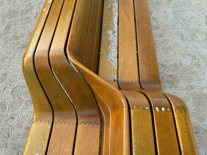 Innovative wooden bench design with curved, interlocking slats showcasing smarter and cooler design creativity.