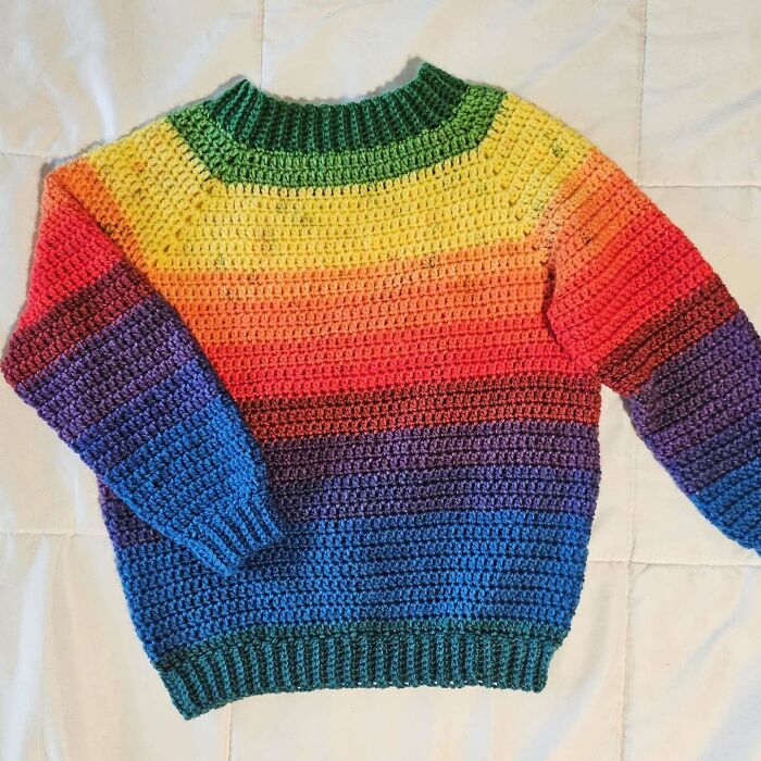 Colorful handmade crochet sweater with rainbow stripes showcasing crochet masterpieces and vibrant yarn craftsmanship.