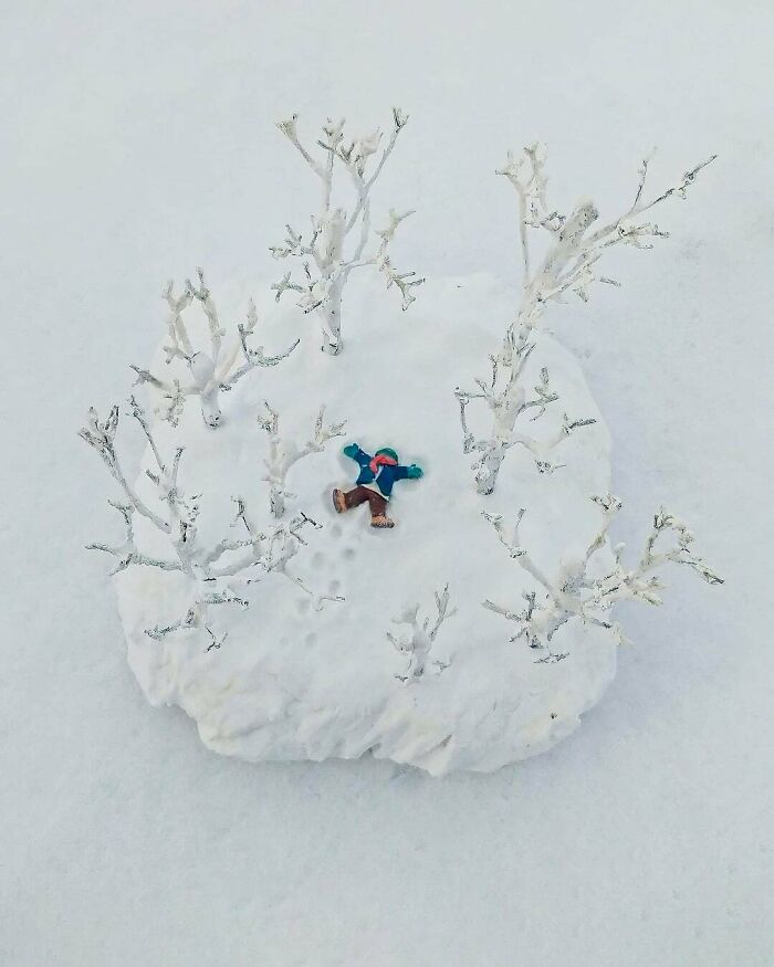 Miniature person making a snow angel surrounded by tiny snowy trees, showcasing creative DIY project ideas.