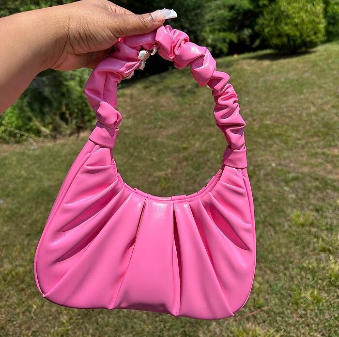 Pink ruched handbag held outdoors, a perfect Valentine's Day find.