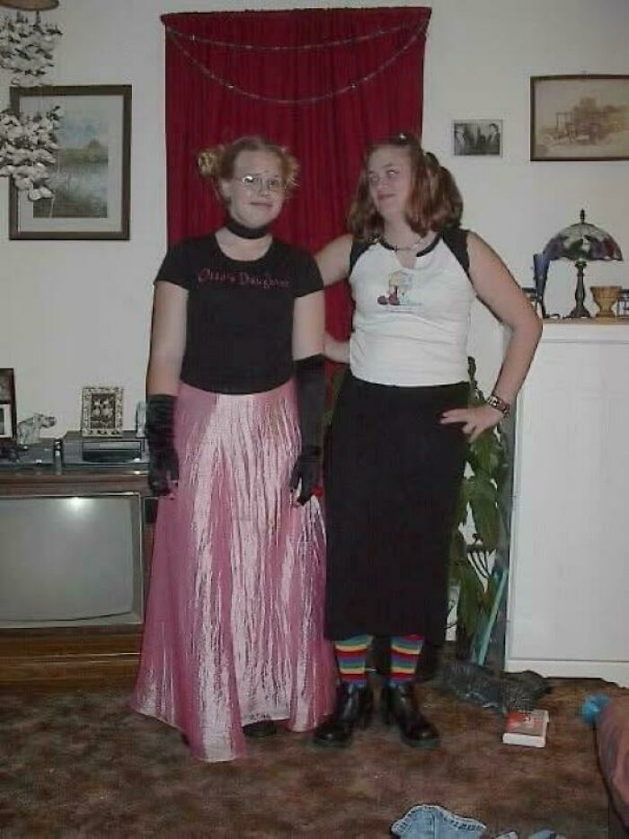 Two women in quirky 90s outfits posing indoors, capturing a moment from their regrettable past photos.