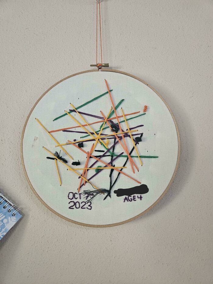 Abstract embroidery hoop featuring colorful stitched lines and patterns, showcasing beautiful embroidery skills by a young artist.