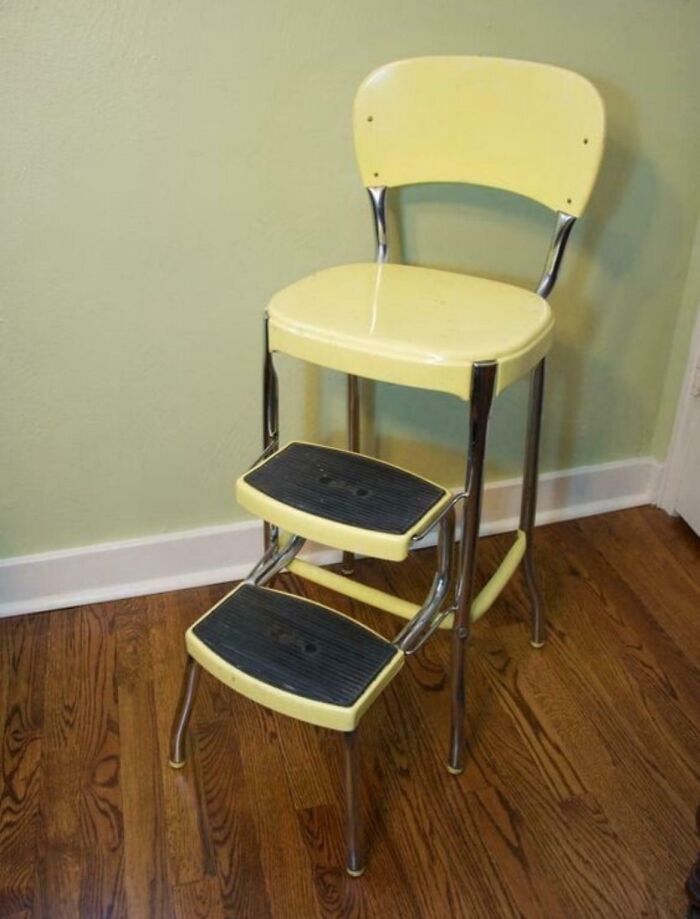 Vintage yellow step stool chair with black tread on wooden floor, evoking childhood memories.