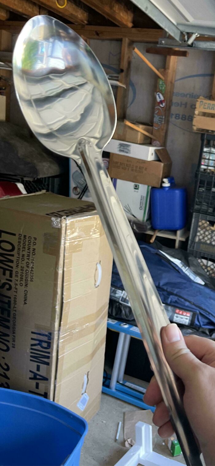 Giant spoon held in hand, highlighting funny online shopping fail.
