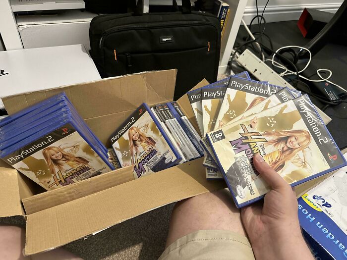 Multiple Hannah Montana PS2 games in a box indicating online shopping scams or fails.