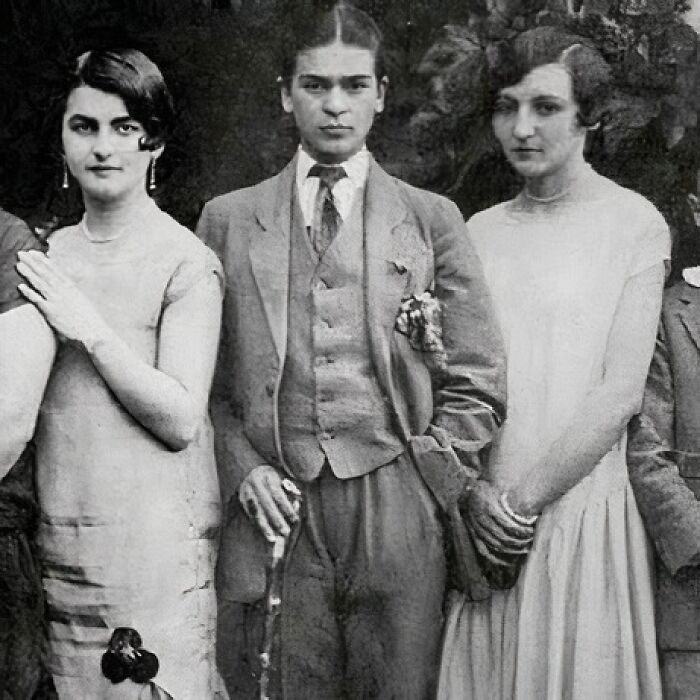Three young people dressed in early 20th-century attire, standing together outdoors.