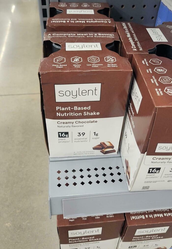 Soylent plant-based nutrition shakes on a store shelf, featuring creamy chocolate flavor and nutritional benefits.