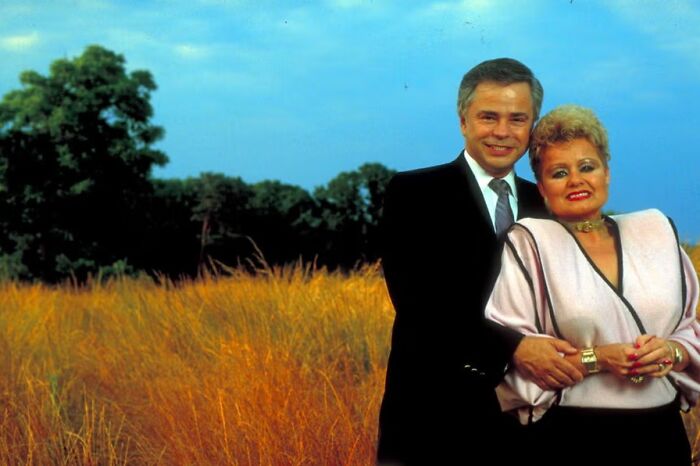 A couple posing in a field, reminiscent of nostalgic childhood moments.