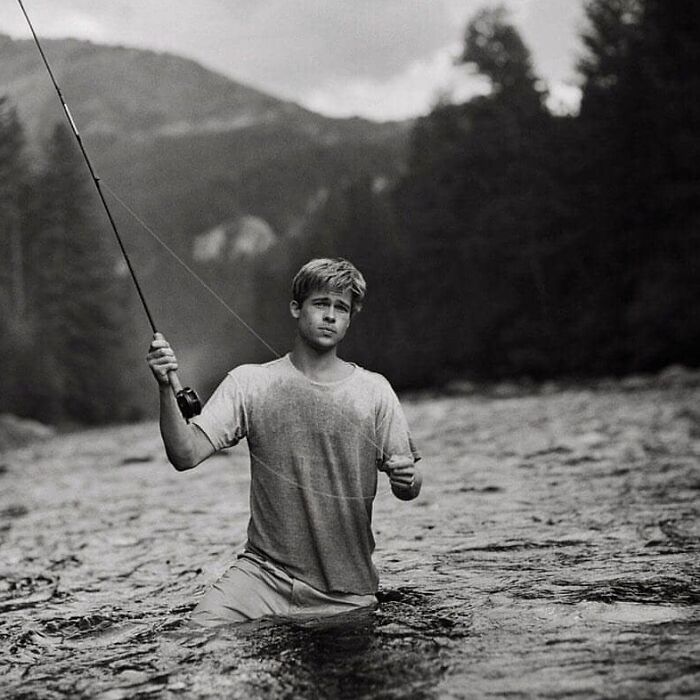 Young person fishing in a river, evoking "History Cool Kids" theme, with trees and mountains in the background.