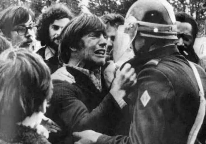 Protester confronts a police officer during a historic demonstration, capturing intense emotions in a past event.