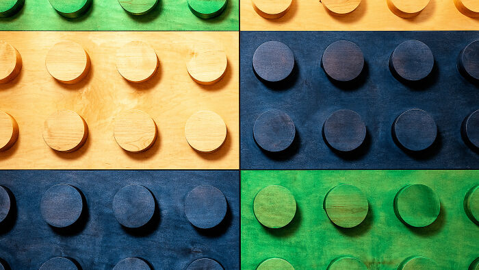 Woodworking project featuring large, colorful wooden blocks resembling LEGO pieces, showcasing craftsmanship and creativity.