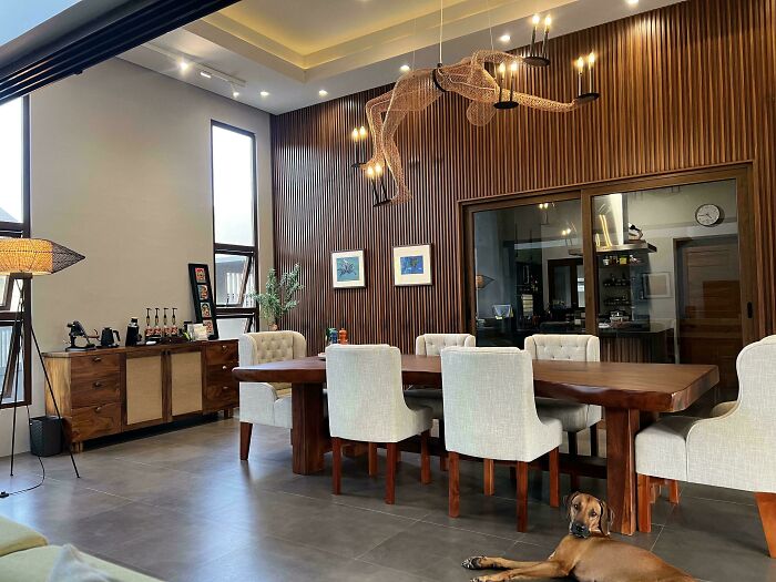 Modern dining room in a beautifully decorated home with wood accents, stylish lighting, and cozy upholstered chairs.