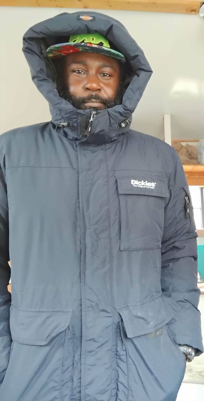 Person in a black Dickies coat found dumpster diving, showcasing a successful discovery.