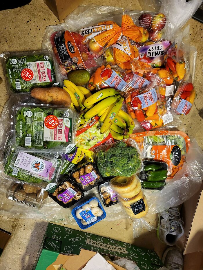 Fresh fruits and vegetables found while dumpster diving, including bananas, peppers, apples, and broccoli.