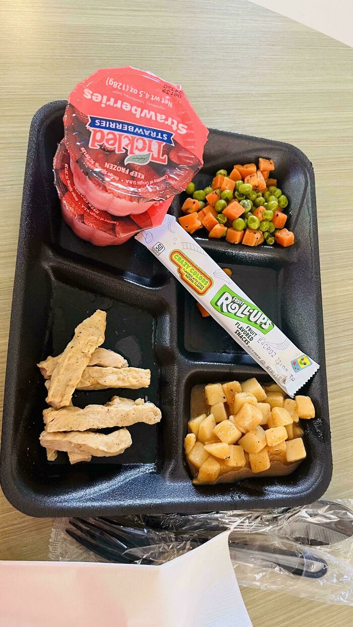 Mildly interesting lunch tray with chicken strips, diced potatoes, peas and carrots, strawberry gel, and a fruit roll-up.